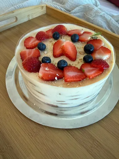 Lemon charlotte with strawberries, blueberries and crushed biscuit