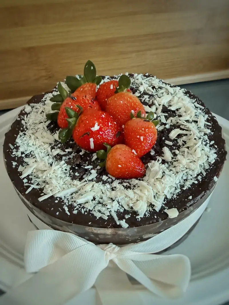 Chocolate marquesa with strawberries, white chocolate shavings and a ribbon