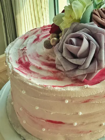 Pink chantilly cake with pearls and flowers, filled with dulce de leche